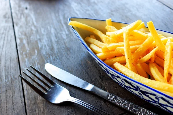 french fries dish or fried potato on the table with film colors tone. soft-focus in the background and over light