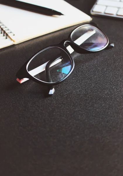 glasses and book on wooden table. film colors tone and soft-focus in the background. over light