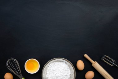 Siyah arka planda pişirme malzemeleri. en üstteki görünüm