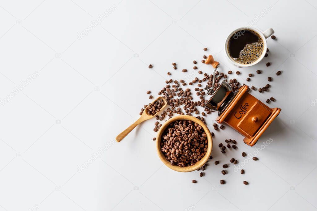 hot coffee, bean and hand grinder on white table background. space for text. top view