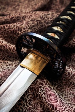 Japon kılıcı sıcak sonbahar renkleriyle saten giyer, arka planda yumuşak odaklanır. ışık üzerinde