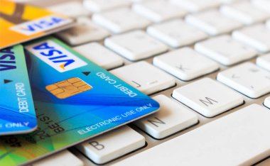 VISA ve Master kart. Kredi kartları dizüstü bilgisayarda, arka planda ise yumuşak odaklı. ışık üzerinde