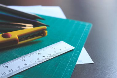 Ahşap masadaki sabit ve ofis ekipmanları film renklerinin tonuyla ve arka planda yumuşak odaklanmayla. ışık üzerinde