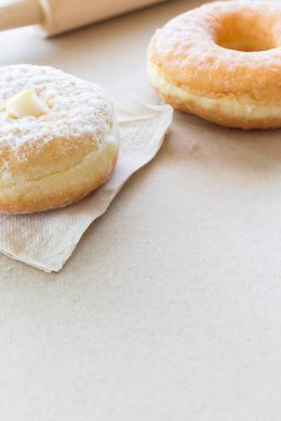 Kağıt dokusu üzerine yakın plan çörek, sıcak sonbahar renkleri, arka planda hafif odaklanma. ışık üzerinde