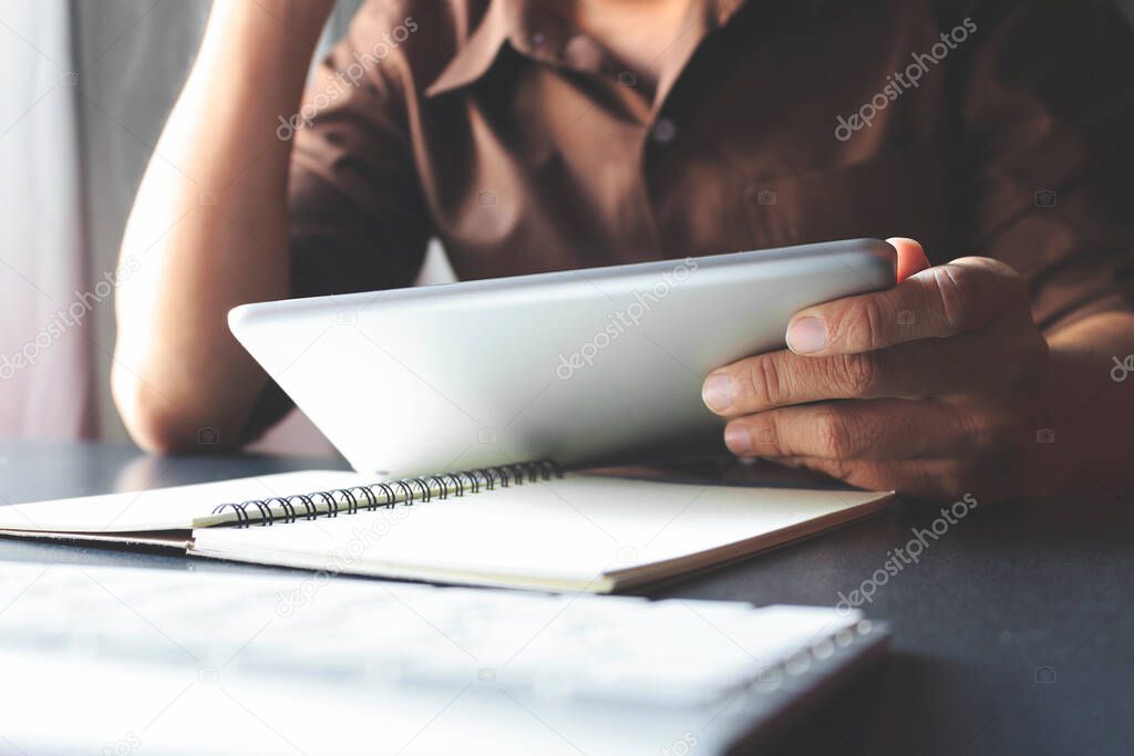 businessman working tablet in office with film colors tone, soft-focus and over light in the background