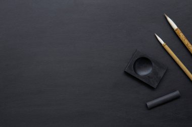 Japon geleneksel yazı fırçasını siyah masaya yakın çekim. Üst Manzara. düz yat
