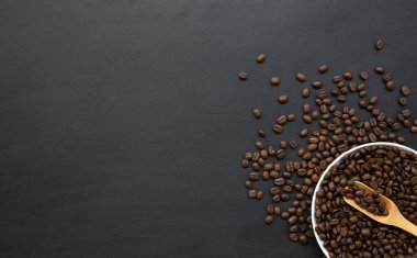 Siyah ahşap zemin üzerinde beyaz fincanda kahve çekirdeği. Üst Manzara. Metin için boşluk