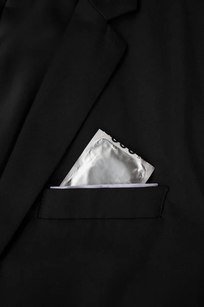 stop aids and hiv concept. closeup condoms in a black suit background