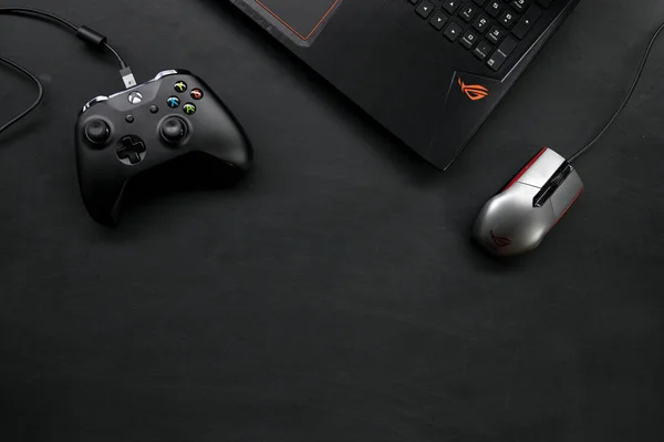 Asus Rog Gaming Notebookのトップビュー 黒い木製の床の背景にMicrosoft Xbox Oneコントローラ 平置き — ストック写真