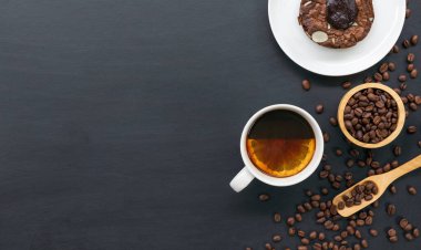 Siyah masa arkasında sıcak kahve, browni, fasulye ve el değirmeni. Metin için boşluk. en üstteki görünüm