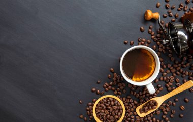 Siyah ahşap arka planda sıcak kahve ve fasulye. en üstteki görünüm
