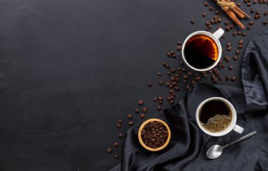 Siyah ahşap arka planda sıcak kahve ve fasulye. en üstteki görünüm