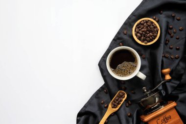 Beyaz masa arkasında bir fincan kahve ve fasulye. en üstteki görünüm