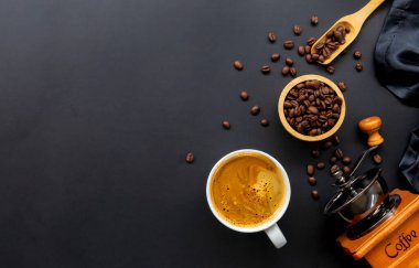 Siyah arka planda bir fincan kahve ve fasulye. en üstteki görünüm