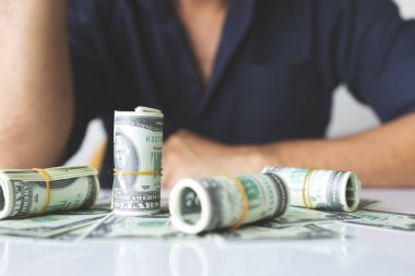 Yakın plan el kameraları bize dolar banknotları tutuyor ve arka planda ışık var.