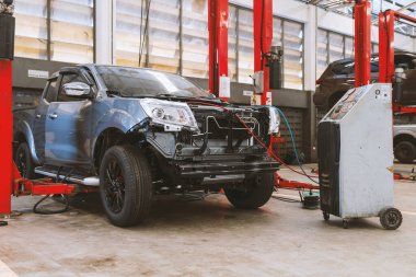 Otomobil tamirhanesinde hafif odaklı ve arka planında ışık olan bir araba.