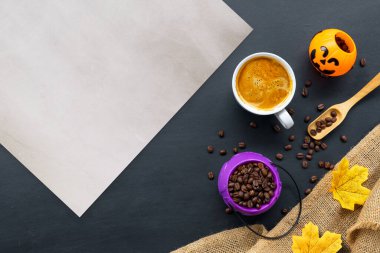 Cadılar bayramı dekorasyonu, koyu arkaplanda sıcak kahve ve fasulye. Düz yat. Metin için alanı kopyala.