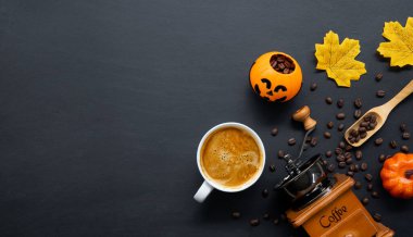 Cadılar bayramı dekorasyonu, koyu arkaplanda sıcak kahve ve fasulye. Düz yat. Metin için alanı kopyala.