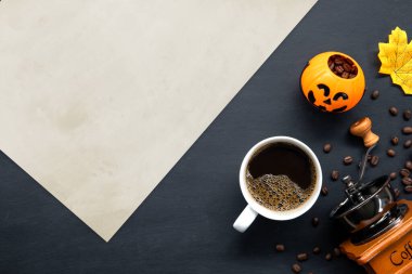 Cadılar bayramı dekorasyonu, koyu arkaplanda sıcak kahve ve fasulye. Düz yat. Metin için alanı kopyala.