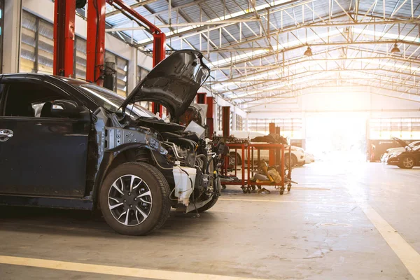 Otomobil tamirhanesinde hafif odaklı ve arka planında ışık olan bir araba.