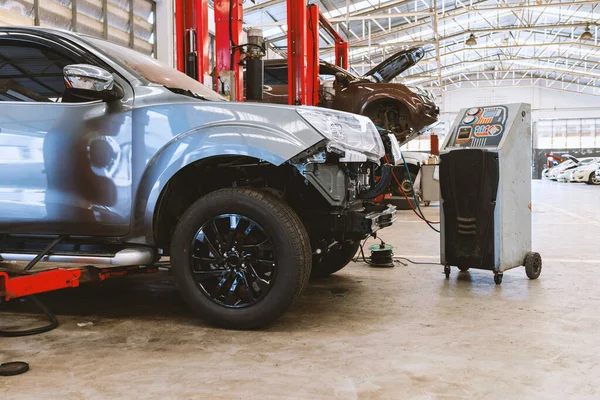 Otomobil tamirhanesinde hafif odaklı ve arka planında ışık olan bir araba.