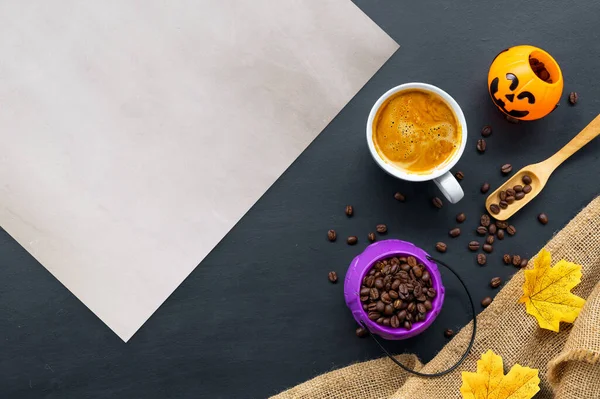 Cadılar bayramı dekorasyonu, koyu arkaplanda sıcak kahve ve fasulye. Düz yat. Metin için alanı kopyala.