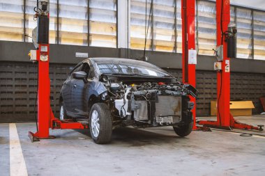 Otomobil tamirhanesinde hafif odaklı ve arka planında ışık olan bir araba.