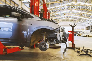 Otomobil tamirhanesinde hafif odaklı ve arka planında ışık olan bir araba.