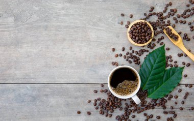 Ahşap zemin üzerinde bir fincan kahve ve fasulye. en üstteki görünüm