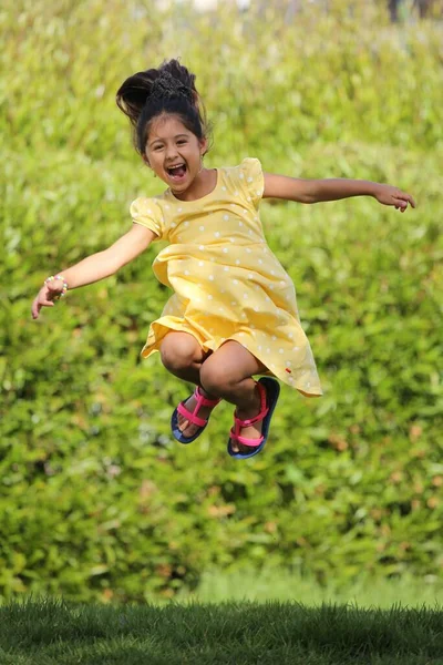 Niña Saltando Con Vestido Amarillo — Foto de Stock