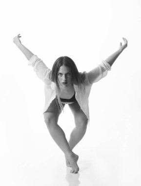 Stüdyo arka planında poz veren genç ve güzel bir dansçı. Siyah ve beyaz. İzole edilmiş