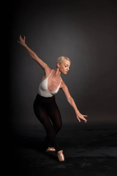 Ballerina dance in studio, black background