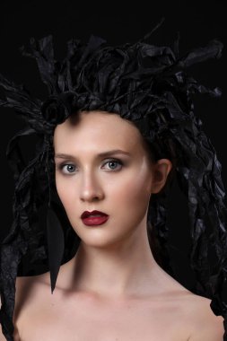 Yaratıcı sanat tarzı görünüş, genç model Whit siyah elbise dolabı, siyah üzerine izole edilmiş.