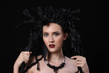 Yaratıcı sanat tarzı görünüş, genç model Whit siyah elbise dolabı, siyah üzerine izole edilmiş.