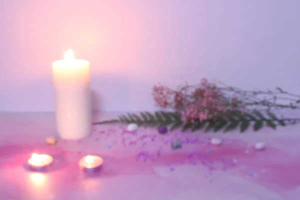 Candlelight and pink flowers on pink background blurry as focus. Romantic feelings.