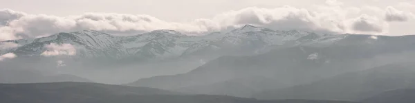 Góry pokryte Zimą śnieg i niskie chmury z nagimi kamieniami. Piękne krajobrazy przyrody w zimie. Widok panoramiczny, Północna Hiszpania. — Zdjęcie stockowe
