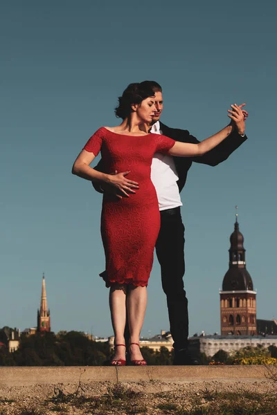 年轻夫妇在旧城的背景下跳舞 在蓝天上被隔离 肖像捕捉到 — 图库照片