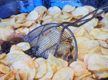 Bir restoranda kaynar yağ bir sürü siyah bir tavada kızartma cips.