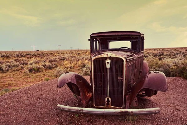 Брошенный автомобиль у входа в раскрашенную пустыню Стоковая Картинка
