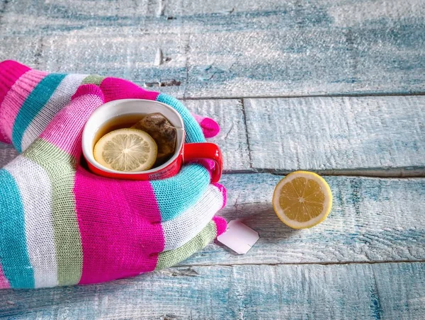 Manos sosteniendo una taza de té con limón . —  Fotos de Stock