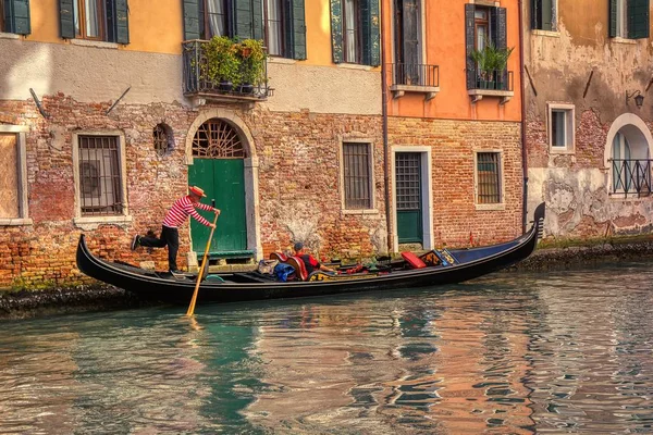 Tourists travel on gondola at canal in Venice, Italy. — Stock Photo, Image