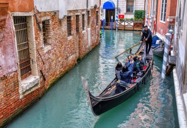 Turistler İtalya 'nın Venedik kanalında gondolla seyahat ediyorlar.. 