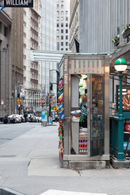 New York, New York - 19 Ağustos 2018: cep telefon Wall Street'te bir gazete bayii içinde erken bir Pazar sabahı A adam denetimleri.