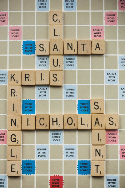 WOODBRIDGE, NEW JERSEY - November 9, 2018: Scrabble tiles spell out variations of Santa Claus on a vintage game board