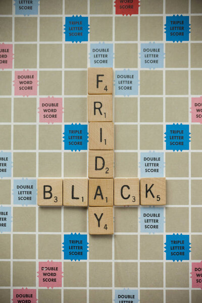 WOODBRIDGE, NEW JERSEY - November 9, 2018: Scrabble tiles spell out "Black Friday" on a vintage game board