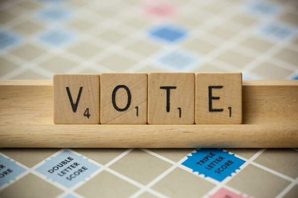 WOODBRIDGE, NEW JERSEY - November 9, 2018: Scrabble tiles spell out the word vote on a vintage game board