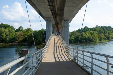 RICHMOND, VIRGINIA - 9 Ağustos 2019: İnsanlar güzel bir yaz gününde Belle Adası asma köprüsünde yürür