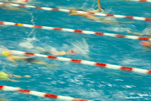 竞技游泳运动员在比赛前在游泳池里热身 这张照片是用长时间曝光拍摄的 以显示运动模糊 — 图库照片