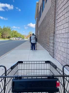 WOODBRIDGE, NEW JERSEY - 16 Nisan 2020: İnsanlar Coronavirus salgını sırasında market alışverişlerini yapmak için Wegmans süpermarketinin önünde kuyrukta bekliyorlar