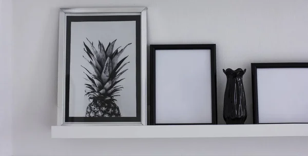 Affischer med ananas och ren ramar på hyllan, modern inredning i svart och vitt, banner — Stockfoto